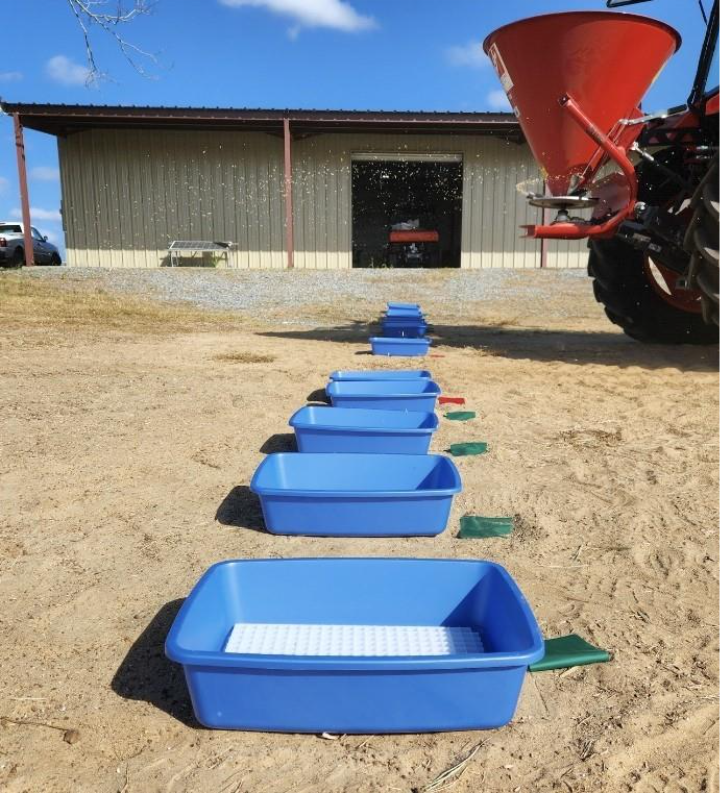Spreader running past the catch pans to demonstrate the importance of not cutting off the spreader prematurely to skew the results of the calibration.