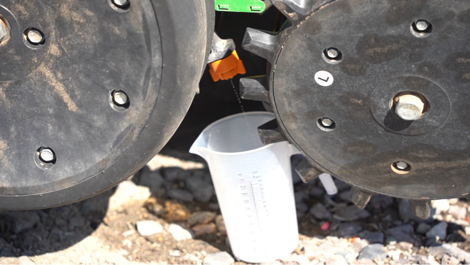 Measuring cup placed under row 1 unit to catch water for calibration.