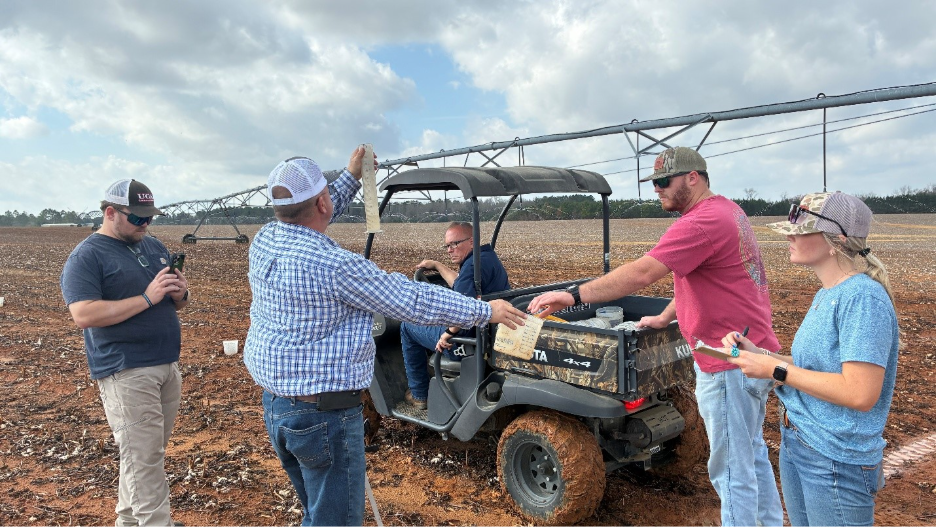 Image of the UGA Ag Water Team using graduated cylinders to measure the water application uniformity along the length of the pivot.